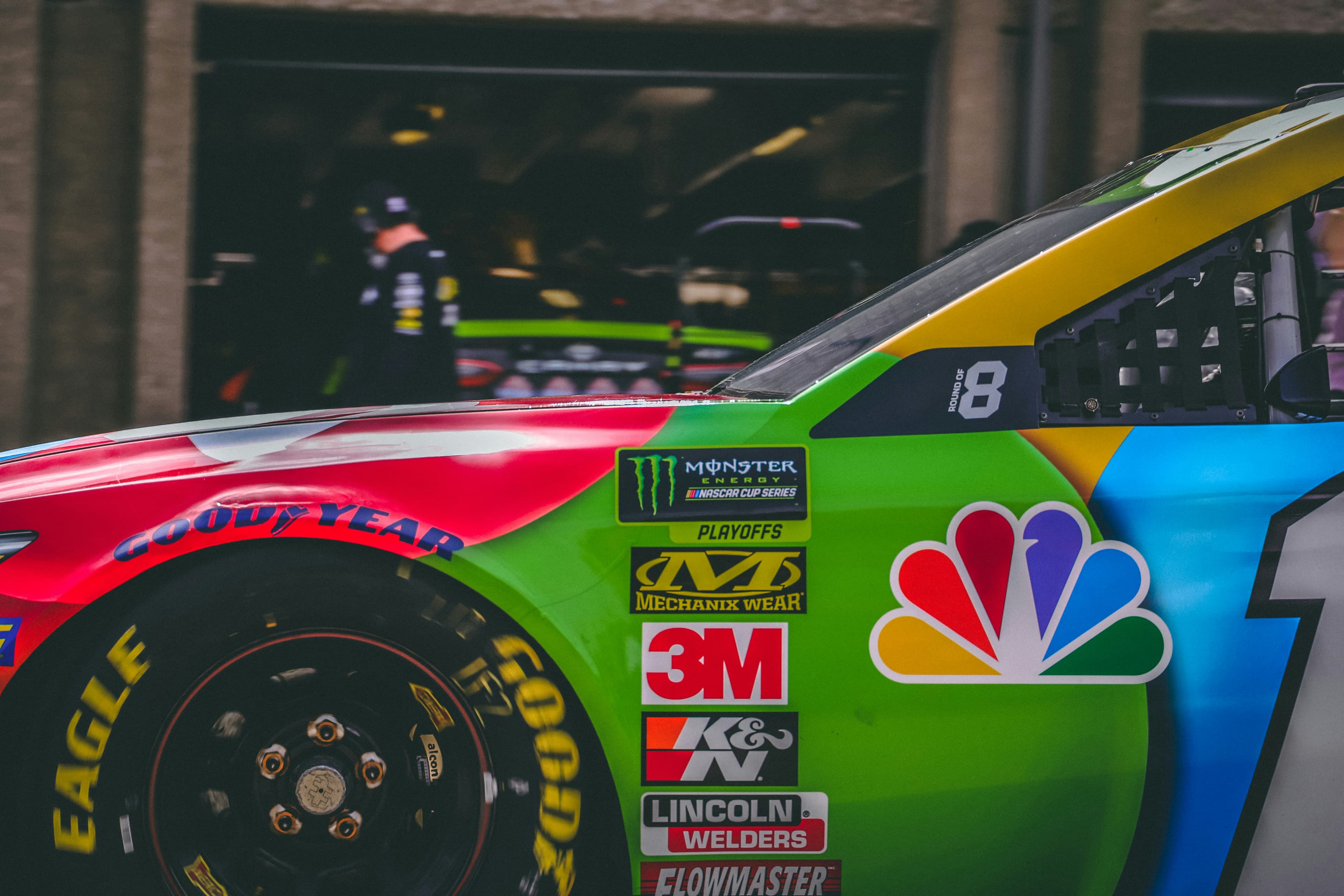 Vibrant NASCAR race car side panel with sponsor decals, NBC logo, and Goodyear tire.